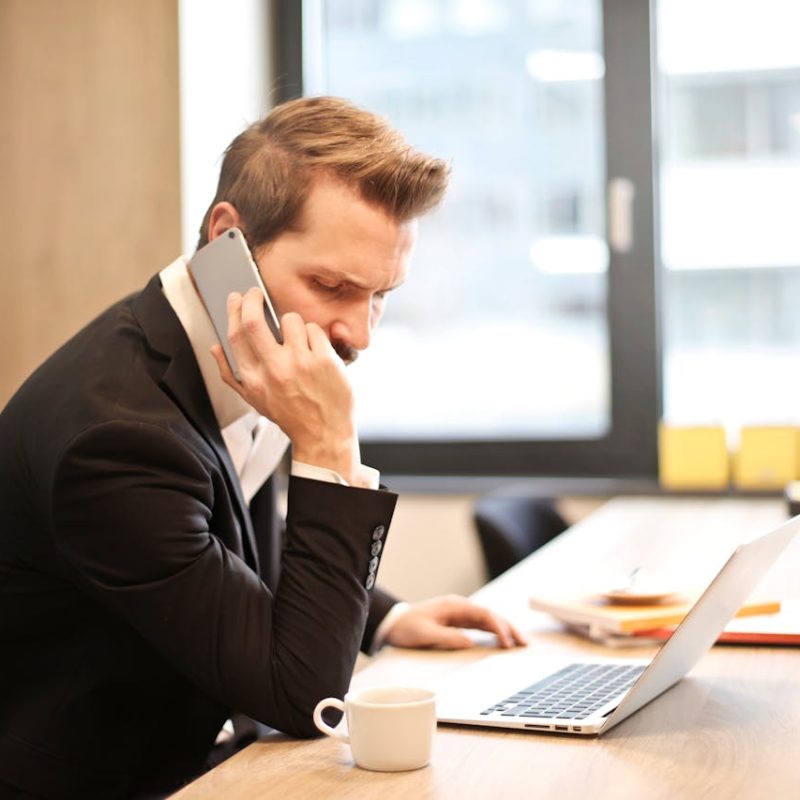 Client B2B frustré au téléphone face à un standard automatique complexe.