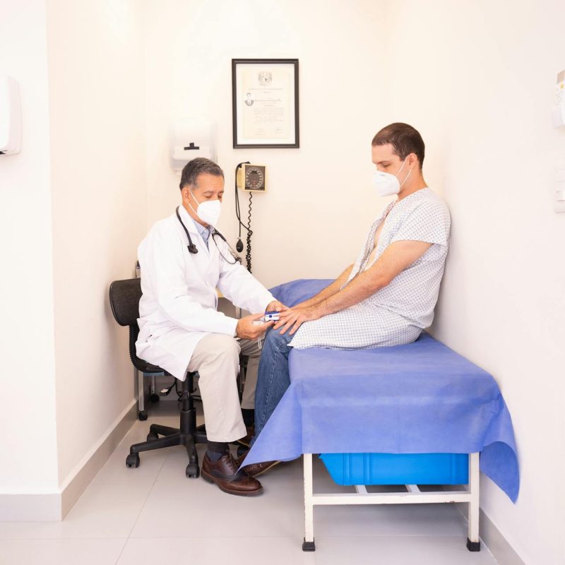 Médecin généraliste s'excusant auprès d'un patient lors d'une consultation interrompue par le téléphone.