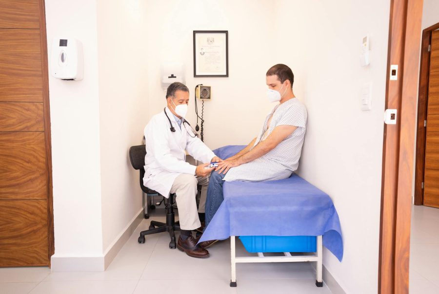 Médecin généraliste s'excusant auprès d'un patient lors d'une consultation interrompue par le téléphone.