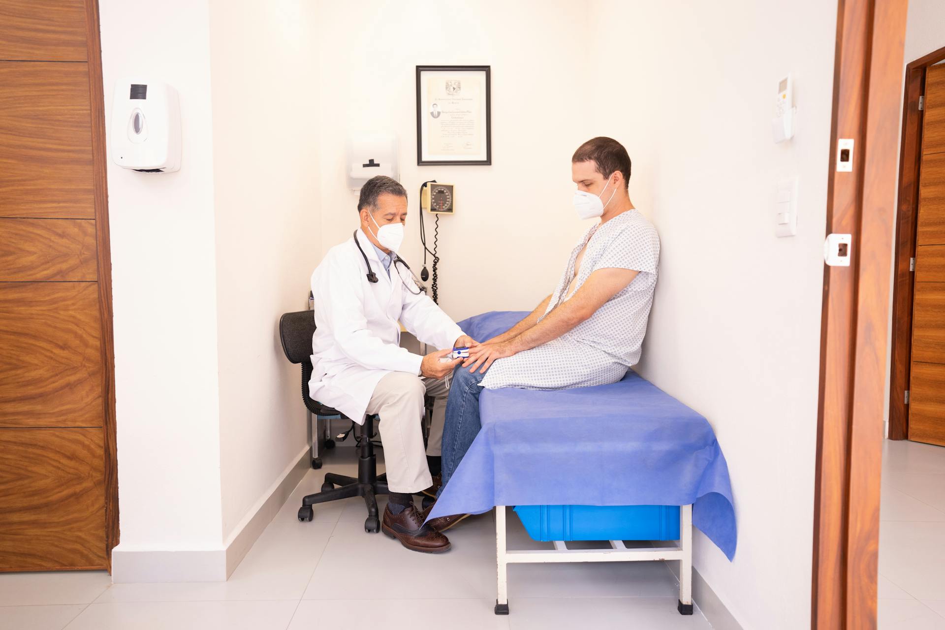 Médecin généraliste s'excusant auprès d'un patient lors d'une consultation interrompue par le téléphone.