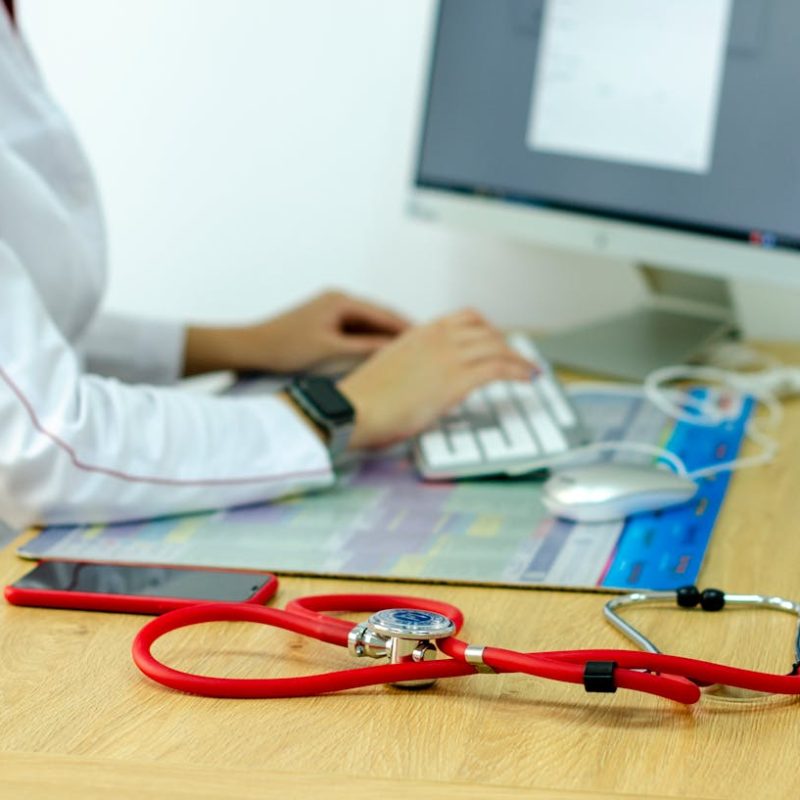 Médecin débordé songeant à un secrétariat médical externalisé pour l'aider.