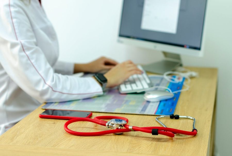 Médecin débordé songeant à un secrétariat médical externalisé pour l'aider.