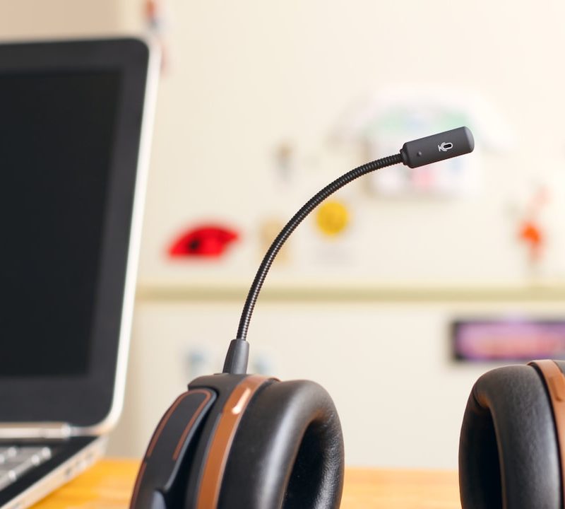 black and brown headset near laptop computer