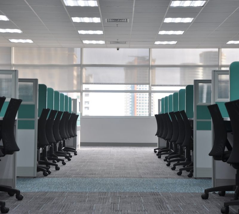 empty black rolling chairs at cubicles